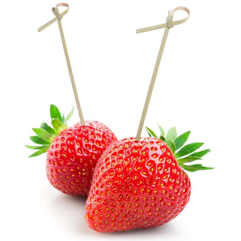 Two bamboo fruit picks with knotted tops set into fresh strawberries