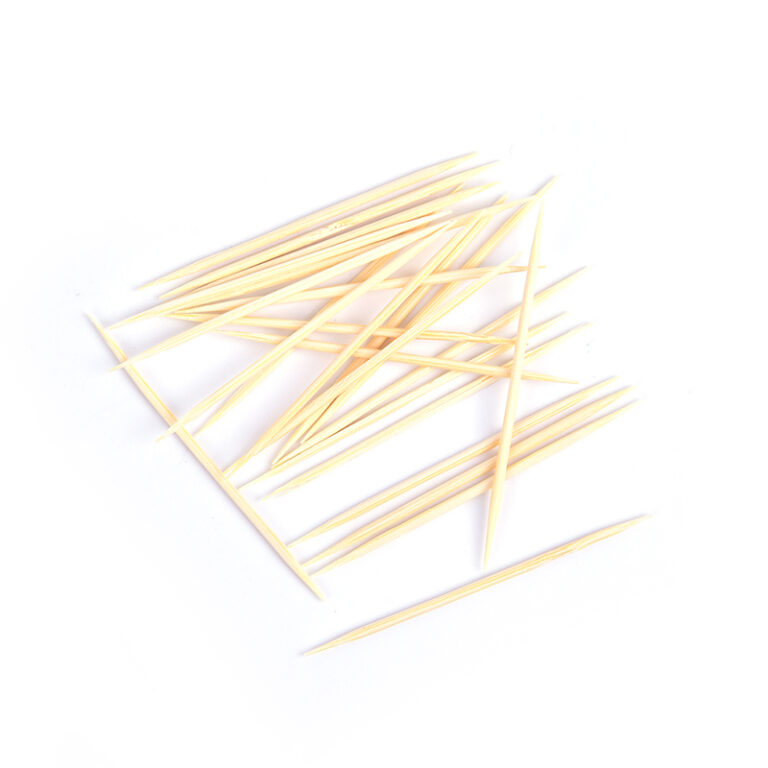 Loose bamboo toothpicks scattered on a white background