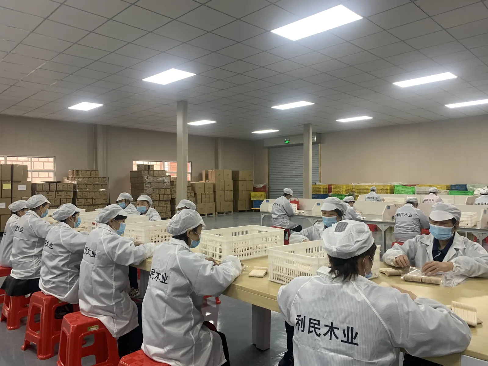 Workers hand-sorting wooden cutlery in the clean room Workers hand-sorting wooden cutlery in the clean room