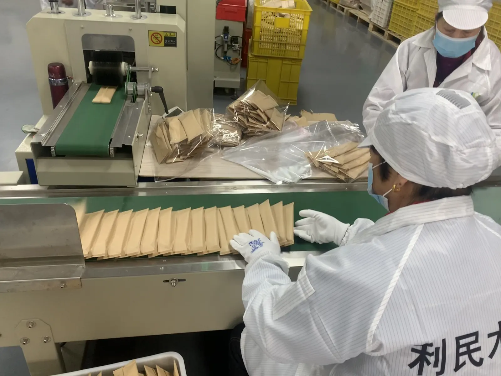 Workers packing wooden cutlery into kraft paper bags